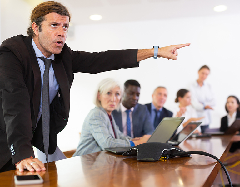In a business meeting, one man dominates the conversation while others listen without enthusiasm