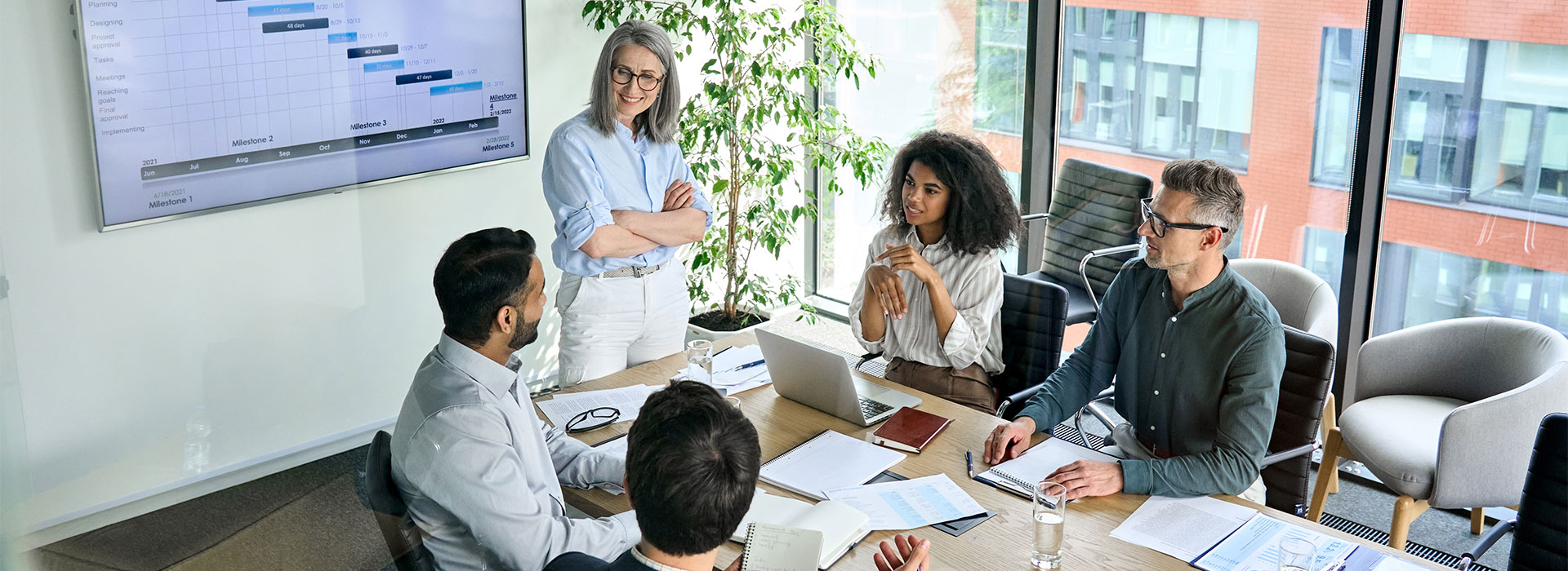 A bright, spacious boardroom where a diverse group of professionals are attending a business meeting